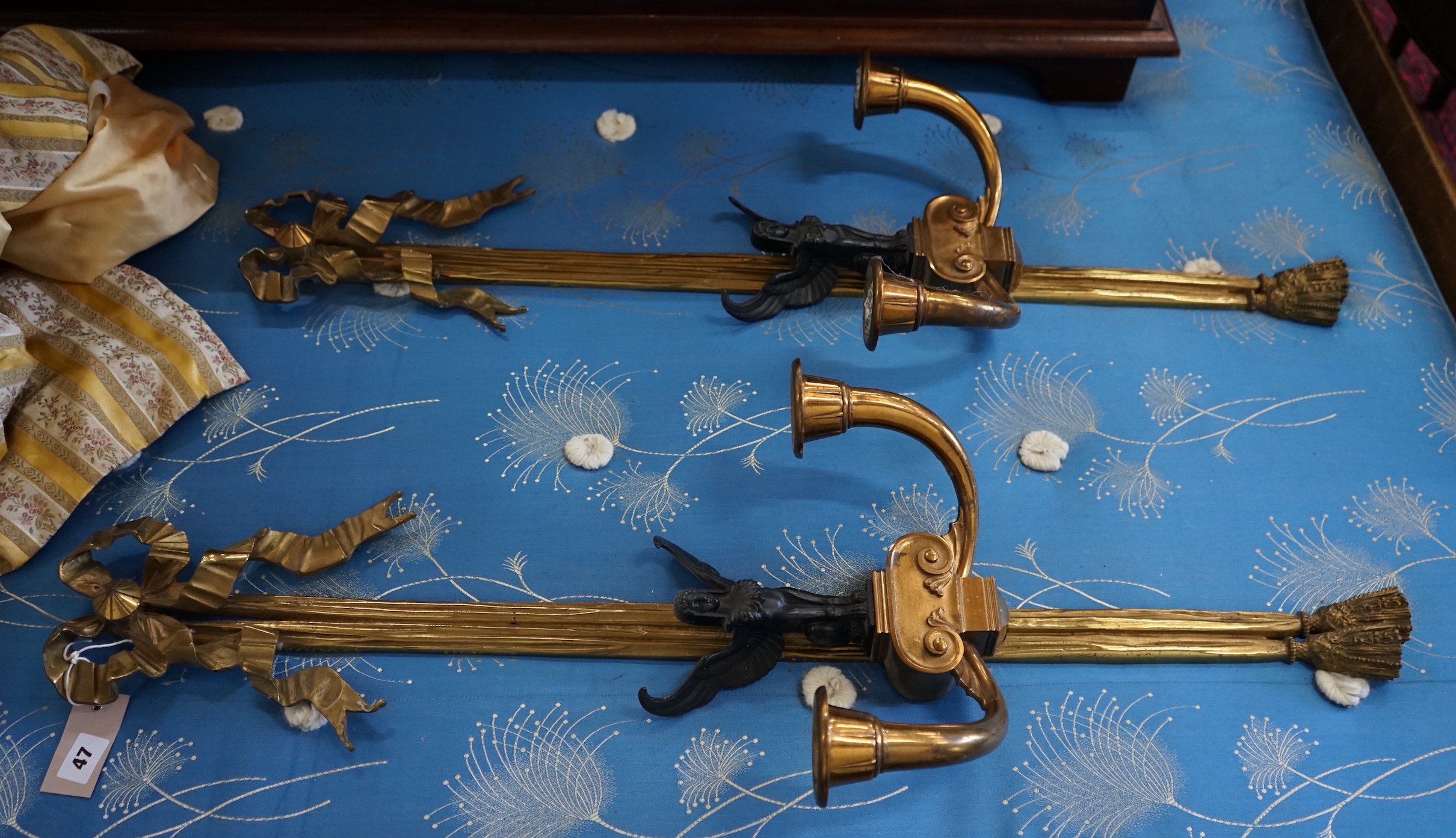 A pair of bronzed and gilt metal Empire style twin branch ribbon fold wall lights, height 95cm